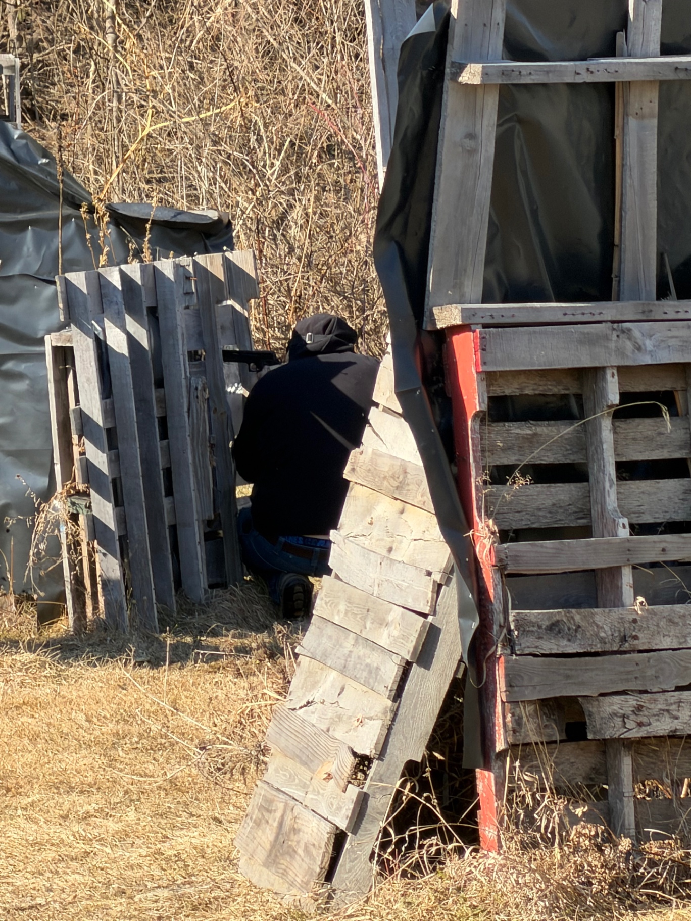 A player crouches behind wooden pallet barriers on the Korhaven field